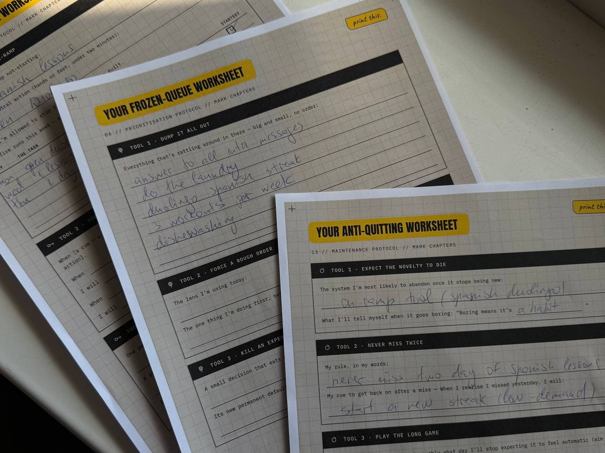 Printed worksheets from the kit — a frozen-queue brain dump and an anti-quitting sheet, both completed in pen